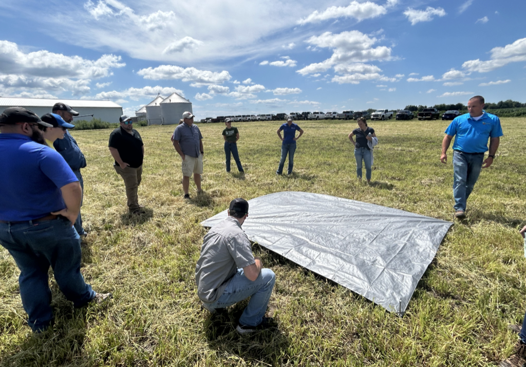 ISAP's Soil Health Specialist, Jim Isermann, demonstrates cover crop seeding distributions after a drone demonstration on Brad Zimmerman's farm in Tazewell County, Illinois.